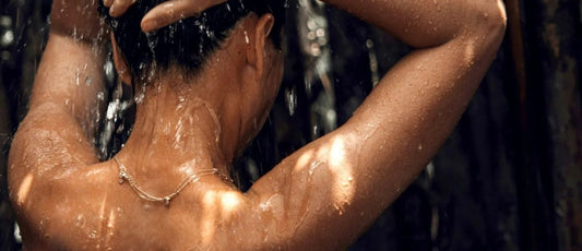 Woman with healthy glowing skin showering with PURITI filtered water