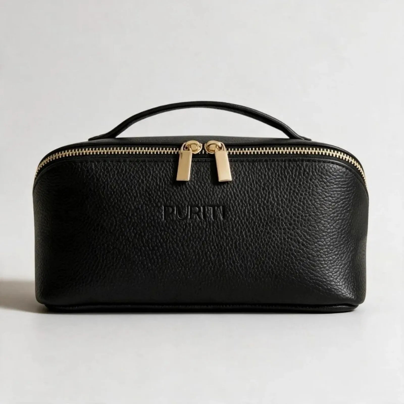 PURITI Beauty Case - Medium sized black pebble leather beauty case with gold zipper on a light gray background
